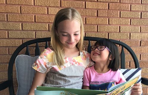 Sarah and her sister reading a book