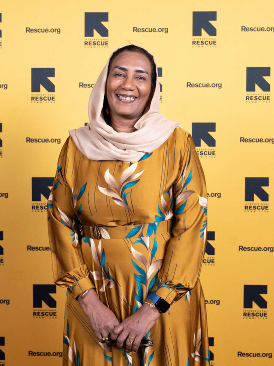 Eatizaz stands facing the camera, smiling, against an IRC branded backdrop.