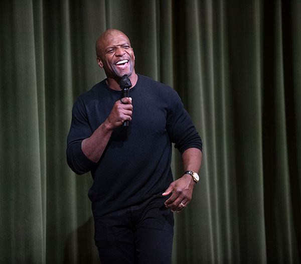 Terry Crews stands while speaking to a crowd.