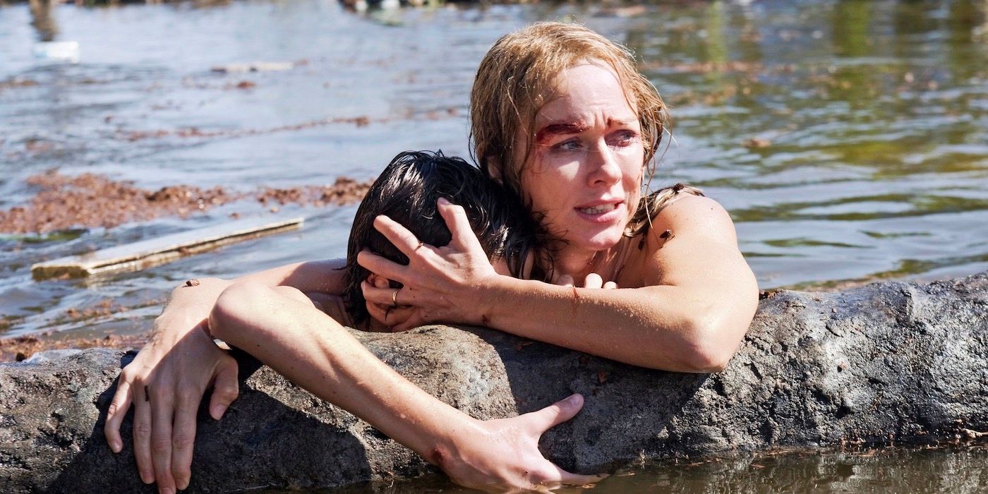 Maria (Naomi Watts) and Lucas (Tom Holland) stuck in a flood, holding onto one another and onto a tree trunk