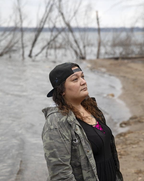 A woman stands near the lake 